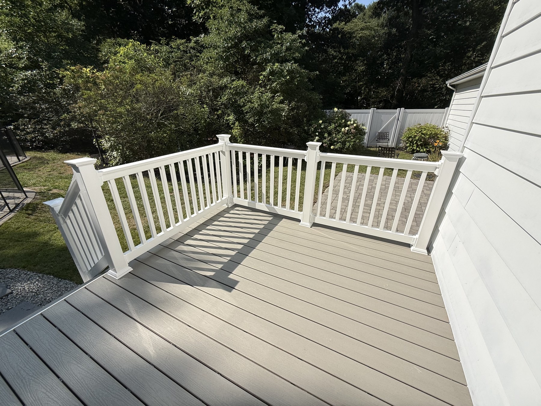 Completed gray composite deck with white railings at a Medford home